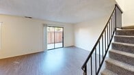 Located at 39058 Agua Vista in Murrieta, CA, this two-story, 2-bedroom, 2-bathroom home offers a practical and well-organized layout across two floors. The main level houses the combined living, dining, and kitchen area, where wood-style flooring runs throughout. The kitchen features gray cabinetry, light stone countertops with a breakfast bar overhang, a gas range, dishwasher, and double sink — all oriented toward the open living space. A sliding glass door in the living room allows natural light to fill the area and provides direct access to a private patio. Carpeted stairs with a sleek black metal railing lead to the upper level, where both bedrooms are situated. Each bedroom offers plush carpet, a window with natural light, a textured ceiling, and closet space. The spacious primary bedroom includes ample room for furnishings. Both bathrooms are clean and functional: one features a full tub/shower combo with white surrounds and chrome fixtures, while the other includes a gray vanity with a large mirror. Additional highlights include an attached garage, multiple closets throughout, and a textured ceiling detail visible across the main living areas. The home's efficient two-floor design maximizes usable space throughout.