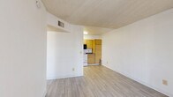 Located at 4401 E 29th St in Tucson, Arizona, this one-bedroom, one-bathroom unit offers a thoughtfully organized single-floor layout designed to maximize every square foot. Light-toned wood-style flooring runs consistently throughout the space, creating a cohesive and clean aesthetic.

The living room is bright and open, featuring a sliding glass door fitted with vertical blinds that allows natural light to fill the room and provides a view of the outdoors. A textured ceiling adds a classic architectural detail found throughout the unit.

The kitchen is efficiently arranged in a galley-style configuration, featuring warm-toned wood cabinetry, laminate countertops, and a full suite of white appliances including a refrigerator, electric range, dishwasher, and over-the-range microwave. The layout allows for practical workflow and ample cabinet storage.

The bedroom is a comfortable, well-proportioned room with a window dressed in vertical blinds that brings in natural light. It connects directly to a dedicated closet complete with built-in shelving and hanging rods, offering organized storage space.

The bathroom includes a full soaking tub and shower combination, a single-sink vanity with wood cabinetry and a granite-style countertop, a mirrored medicine cabinet, and wood-style flooring that ties seamlessly into the rest of the unit.
