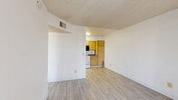Located at 4401 E 29th St in Tucson, Arizona, this one-bedroom, one-bathroom unit offers a thoughtfully organized single-floor layout designed to maximize every square foot. Light-toned wood-style flooring runs consistently throughout the space, creating a cohesive and clean aesthetic.

The living room is bright and open, featuring a sliding glass door fitted with vertical blinds that allows natural light to fill the room and provides a view of the outdoors. A textured ceiling adds a classic architectural detail found throughout the unit.

The kitchen is efficiently arranged in a galley-style configuration, featuring warm-toned wood cabinetry, laminate countertops, and a full suite of white appliances including a refrigerator, electric range, dishwasher, and over-the-range microwave. The layout allows for practical workflow and ample cabinet storage.

The bedroom is a comfortable, well-proportioned room with a window dressed in vertical blinds that brings in natural light. It connects directly to a dedicated closet complete with built-in shelving and hanging rods, offering organized storage space.

The bathroom includes a full soaking tub and shower combination, a single-sink vanity with wood cabinetry and a granite-style countertop, a mirrored medicine cabinet, and wood-style flooring that ties seamlessly into the rest of the unit.