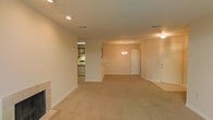 Located at 440 Cross Park Dr. in Pearl, Mississippi, this single-floor property offers a clean, functional layout with a welcoming sense of openness. The main living area is generously proportioned, featuring wall-to-wall carpet in a neutral tone that adds warmth and comfort underfoot. Recessed lighting in the ceiling provides even, ambient illumination throughout the space, complemented by a decorative chandelier that adds a subtle touch of elegance near the entryway.

The open floor plan connects the living area to a separate kitchen space, visible through an interior passthrough or opening in the wall. The kitchen is equipped with appliances including a range and refrigerator, and features a countertop area that could serve as a breakfast bar. Crisp white walls and white-paneled doors throughout contribute to a bright, airy atmosphere that feels clean and move-in ready.

A second ceiling fan fixture is visible toward the rear of the living space, enhancing air circulation throughout the home. The layout flows naturally from the main living zone toward interior doorways, suggesting a practical and well-organized floor plan. Overall, the space presents a straightforward, comfortable environment well-suited for everyday living in the Pearl, Mississippi area.