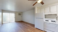 This one-bedroom, one-bathroom unit at 44221 Kingtree Ave in Lancaster, California offers a straightforward, efficiently designed single-floor layout. Light wood-style flooring runs consistently throughout the entire unit, creating a cohesive and clean aesthetic across all rooms.

The living area is the largest space in the unit, featuring white walls, a sliding glass door that introduces natural light and provides outdoor access, and a wall-mounted air conditioning unit for climate control. The open layout connects directly to a compact kitchen equipped with white cabinetry, a white range, and a refrigerator.

The bedroom is a well-proportioned private retreat with a window that allows natural light to enter. It features a built-in sliding-door closet, offering practical storage. A hallway connects the bedroom to the rest of the unit.

The bathroom maintains the same clean, white palette seen throughout. It includes a shower-tub combination, a toilet, and a vanity with a white cabinet base, white countertop, and a wall-mounted mirror with overhead lighting. Light wood flooring continues into this space, tying the unit together visually.

Overall, the unit presents a clean, minimal interior with consistent finishes, making it a functional and straightforward space in Lancaster, CA.