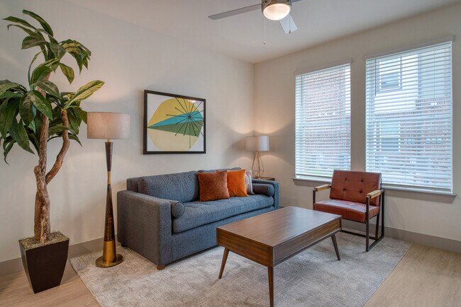 Invitable Oakwood Trails: una comunidad para mayores de 62 años en Spring, TX, con sala de estar de diseño abierto, grandes ventanales para luz natural y pisos de tablones resistentes. - Oakwood Trails - A 62+ Community