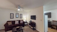 Located at 20 Old Yellow Springs Road in Fairborn, Ohio, this single-floor residence offers a thoughtfully organized layout with a comfortable and functional living environment. The living room serves as the central gathering space, featuring plush carpeting, a ceiling fan with integrated lighting, and ample room for seating arrangements. Neutral wall tones throughout the home create a clean, versatile backdrop. The galley-style kitchen is equipped with dark cabinetry providing generous storage, a full-size refrigerator, an electric range, a stainless steel sink, and light hardwood flooring that adds warmth to the space. A dedicated dining area adjacent to the kitchen features a large window with outdoor views, allowing natural light to fill the room. The primary bedroom offers carpeted flooring and a sizable closet, while a second bedroom functions well as a home office or guest room, complete with a window overlooking greenery. The full bathroom includes a shower-tub combination, a vanity sink, and a mirrored medicine cabinet. Throughout the home, the layout flows efficiently, connecting each room with ease and providing a practical, comfortable living experience.