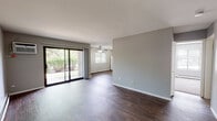 Located at 710 Westmoreland Dr in Vernon Hills, Illinois, this single-floor unit offers a straightforward, functional layout with a clean, neutral aesthetic throughout. The living area is a standout feature, characterized by rich, dark hardwood-style flooring, soft gray walls, and generous natural light streaming in through a large sliding glass door that opens to a view of lush greenery. A ceiling fan overhead and baseboard heating along the walls ensure year-round comfort. The open feel of the living space is further enhanced by a secondary window, bringing in additional daylight.

The kitchen is semi-open to the main living area, separated by a partial wall that doubles as a breakfast bar. Warm oak cabinetry provides ample storage, complemented by dark countertops, a gas range, and a full-size refrigerator. Dark hardwood-style flooring continues seamlessly from the living area into the kitchen, maintaining a cohesive look.

The bedrooms are carpeted in a neutral tone, each featuring baseboard heating and windows with blinds that allow for natural light while maintaining privacy. The full bathroom includes an oak vanity with dark countertops, a large mirror with overhead lighting, and a tub-shower combination, all finished with hardwood-style flooring for easy maintenance.
