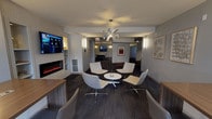 Located at 555 W Kinzie St in Chicago's vibrant River North neighborhood, this single-floor amenity space offers a thoughtfully designed collection of resident-focused areas. The central lounge sets a welcoming tone with a sleek electric fireplace framed by built-in shelving, a large wall-mounted TV, and a sculptural chandelier overhead. Modern swivel chairs arranged around a round table create an inviting social hub, while vertical wall sconces provide warm, ambient lighting throughout.

Adjacent to the lounge, a game room features a full-size billiards table and additional entertainment options, flowing naturally from the communal areas. A dedicated private screening room delivers a true cinematic experience, equipped with tiered rows of leather reclining seats, a large projection screen, surround sound speakers, and subtle floor lighting for an immersive atmosphere.

A co-working area offers counter-height communal tables with city views through large windows, ideal for focused work or collaboration. A separate business center houses a row of desktop computers and framed artwork, catering to residents' professional needs. Textured carpet flooring and a neutral, contemporary color palette tie the entire space together, creating a cohesive and functional amenity floor well-suited for both work and leisure.