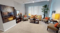 This single-floor residence offers a thoughtfully designed layout that balances comfort and functionality across its living spaces. The expansive living room serves as the heart of the home, featuring soft blue-gray walls, plush carpeting, and a track lighting system overhead. Large windows with vertical blinds allow for generous natural light, creating an open and airy atmosphere throughout.

The kitchen is well-equipped with light maple cabinetry, dark granite countertops, stainless steel appliances including a refrigerator, dishwasher, microwave, and electric range, complemented by tile flooring. Ample cabinet storage and a double basin sink make this a highly functional culinary space.

The primary bedroom is a comfortable retreat with carpeted flooring, a ceiling fan, and closet access, while a secondary bedroom offers similarly cozy accommodations with its own closet. A smaller third bedroom provides flexible space suited for guests or a home office.

Both bathrooms are finished with dark granite countertops, undermount sinks, tile flooring, and wood cabinetry. One bathroom features a glass-enclosed walk-in shower with tile surround, while the other serves as a well-appointed vanity space. Neutral gray walls throughout the residence create a cohesive and calming aesthetic from room to room.