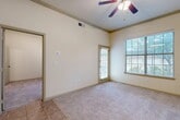 Located in Lewisville, TX, this well-designed one-bedroom, one-bathroom unit offers a thoughtfully arranged single-floor layout that maximizes every square foot. The living room is bright and welcoming, featuring warm neutral tones, plush carpet, a ceiling fan with light fixture, and two windows with blinds that invite natural light. A direct-access door provides convenient outdoor entry from this space. Tile flooring in the entry transitions smoothly into the carpeted living and sleeping areas, creating a clear and functional flow throughout the unit. The kitchen is laid out in a galley style with tile flooring, wood-toned cabinetry, a built-in breakfast bar, and includes a refrigerator, range, and microwave. Adjacent to the kitchen, a dedicated dining area offers a natural gathering space. The bedroom is comfortably sized and features a standout built-in desk with shelving beside a window, ceiling fan, and plush carpet—ideal for both rest and productivity. Five closets provide exceptional storage throughout the unit. The bathroom is finished with warm wood cabinetry, a tile-surround tub and shower combo, and tile flooring. An in-unit laundry area adds everyday convenience to this efficiently designed home.