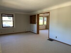 View from living room to dining room- large spaces, brand new wool carpet, working wood fireplace - 342 NE Beyrl Ter