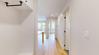 Located in Calgary's vibrant T2T neighbourhood, Unit 206 at 829 Royal Ave SW is a thoughtfully designed one-bedroom, two-bathroom residence that maximizes its compact footprint with a clean, modern aesthetic. The unit features light-toned hardwood flooring throughout the main living areas and bedroom, contributing to a bright and cohesive look across the space.

The galley-style kitchen is well-appointed with white flat-panel cabinetry extending to the ceiling, a white subway tile backsplash, stainless steel appliances including a gas range and dishwasher, and a peninsula with pendant lighting that connects to the living area. Recessed lighting adds functionality to the kitchen space.

The living area benefits from a sliding glass door that opens to a private balcony, allowing natural light to fill the room and providing views of the surrounding neighbourhood. The bedroom is a cozy, dedicated space with clean white walls and the same warm hardwood flooring.

Both bathrooms maintain the unit's clean design language, featuring white cabinetry with matte black hardware, undermount sinks, and large mirrors. The full bathroom includes a tiled tub-surround and grey floor tile. A functional hallway with built-in storage connects the rooms, completing this efficiently planned modern unit.
