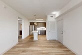 Located at 209 Courtney Lakes Cir in West Palm Beach, FL, this thoughtfully designed one-bedroom, one-bathroom residence offers a clean, modern aesthetic across a single floor. Light wood-style flooring flows seamlessly throughout the space, lending warmth and visual continuity to every room.

The open-concept living and kitchen area forms the heart of the home. The kitchen is well-appointed with rich dark wood cabinetry reaching to the ceiling, white quartz countertops, a subway tile backsplash, and a full suite of stainless steel appliances including a refrigerator, range, microwave, and dishwasher. A central island with pendant lighting provides additional prep space and serves as a natural gathering point. The living area benefits from multiple windows and a sliding glass door that invites natural light, complemented by a ceiling fan overhead.

The bedroom is a comfortable, well-lit retreat featuring two windows with blinds and a dedicated walk-in closet outfitted with wire shelving for organized storage. A hallway connects the main living areas to the bedroom and bathroom, where a vanity with dark wood cabinetry, white countertop, and a framed mirror accompanies a full tub-shower combination with tile surround. A convenient in-unit stacked washer and dryer is tucked within a dedicated closet space, completing this practical and stylish West Palm Beach residence.