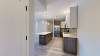 Located at 1 W Quincy St in Westmont, IL, this thoughtfully designed one-bedroom, two-bathroom residence offers a comfortable and modern living experience across a single floor. The open-concept kitchen and living area serves as the heart of the home, showcasing two-tone cabinetry with rich wood-grain lower cabinets and crisp white uppers, a grey subway tile backsplash, stainless steel appliances, and a spacious center island with a white quartz countertop and pendant lighting above. Light wood-tone flooring runs throughout the main living areas, enhancing the bright and airy ambiance. The generously sized bedroom features plush carpeting, neutral grey walls, and a window that brings in natural light. Two well-appointed bathrooms include clean tile flooring, modern vanities with white countertops, and chrome fixtures; one bathroom features a glass-enclosed walk-in shower. A dedicated laundry room with full-size washer and dryer adds everyday convenience. Additional storage is provided by a closet, and a welcoming entrance completes the layout. The overall aesthetic is clean, contemporary, and move-in ready, making this Westmont residence a polished and functional place to call home.