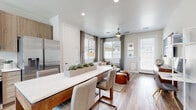 This thoughtfully designed single-floor residence offers a seamless blend of modern style and everyday functionality. The open-concept layout connects the kitchen, dining, and living areas into one cohesive, light-filled space. The kitchen is equipped with stainless steel appliances—including a refrigerator, range, built-in microwave, and dishwasher—complemented by light wood cabinetry, white quartz countertops, and wood-look flooring that flows throughout the home. A central island with a matching quartz surface provides additional prep and dining space, with seating for casual meals. The adjoining living area is bright and welcoming, featuring a ceiling fan, large windows with blinds and drape accents, and direct access to the outdoors through a full-lite glass door. The primary bedroom offers a comfortable retreat with natural light from a large window, a ceiling fan, and ample floor space. A secondary bedroom provides additional flexibility and similarly benefits from natural light. The bathroom is finished with warm wood-toned cabinetry, a white quartz vanity countertop, an undermount sink, a glass-enclosed shower and tub combination, and a hexagonal wall-mounted shelf for decorative storage. Recessed lighting, neutral wall tones, and consistent wood-look flooring throughout tie the entire space together with a clean, contemporary aesthetic.