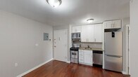 Located at 200 Deal Lake Dr in Asbury Park, New Jersey, this single-floor residence offers a clean, functional layout with consistent finishes throughout. Rich, dark hardwood flooring runs across the living areas and bedrooms, lending warmth and a cohesive aesthetic to the entire space.

The kitchen is efficiently designed and fully equipped with stainless steel appliances, including a gas range, built-in microwave, dishwasher, and refrigerator. White shaker-style cabinetry extends to the ceiling, maximizing storage, while granite countertops provide a polished work surface. A stainless steel sink completes the practical setup.

The residence includes multiple bedrooms, each featuring the same rich hardwood flooring and neutral gray walls. Every bedroom is fitted with windows dressed in horizontal blinds, allowing for adjustable natural light, and baseboard heating units ensure comfort year-round. The rooms offer a calm, versatile environment suitable for a variety of uses.

The bathroom is finished with light tile flooring, white subway tile surrounding the shower-tub combination, and a white vanity with ample storage. A window provides natural ventilation and light.

Additional details include a visible electrical panel near the entryway and a straightforward, single-level floor plan that ensures easy accessibility and efficient use of space throughout.
