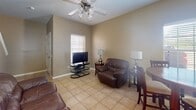 Located at 900 Travis St in Mission, Texas, this two-story home offers a functional and comfortable layout across two levels connected by a carpeted staircase. The main living area is finished with neutral-toned walls and light ceramic tile flooring throughout, creating a cohesive and easy-to-maintain interior. The living room provides ample space for seating and entertainment, with a ceiling fan overhead and a window fitted with blinds that allows natural light to filter in. Adjacent to the living area, the kitchen stands out with warm oak cabinetry, a tile backsplash, granite-topped center island, stainless steel appliances, pendant lighting, and generous counter space — well-suited for everyday cooking and entertaining. A dining area with bar-height seating sits nearby. The bedroom is a well-proportioned room featuring a ceiling fan, tiled flooring, and a bright window with exterior views. An additional room on the upper level offers flexible use as a bedroom or office, also featuring natural light from a window and a ceiling fan. The bathroom includes a full tub-shower combination with chrome fixtures and overhead cabinetry for storage. Throughout the home, the warm, earthy color palette and consistent tile flooring lend a unified, welcoming ambiance.