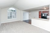 Located on Academy Drive in Rochester Hills, Michigan, this single-floor residence offers a thoughtfully designed layout that balances open communal spaces with private retreats. The living area immediately draws attention with its vaulted ceiling and a striking arched window that floods the room with natural light, creating an airy and welcoming atmosphere. Plush carpeting covers the living area floor, while wood-look flooring transitions seamlessly into the adjoining dining and kitchen spaces. A sliding glass door fitted with vertical blinds provides access to the outdoors and adds additional light to the open-concept area.

The kitchen is well-appointed with warm-toned wood cabinetry, granite-style countertops, and a full suite of black appliances, including a refrigerator, range, and built-in microwave. A peninsula counter visually connects the kitchen to the living and dining areas, making the space well-suited for everyday living and entertaining.

The bedroom features plush carpeting and a window with exterior views. The bathroom is finished with tile flooring, a tiled tub-shower surround, a granite-top vanity with rich wood cabinetry, and a large mirror. A dedicated laundry room includes an in-unit washer and dryer alongside a utility sink, providing added convenience.