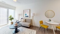 Located at 502 E Main St in the heart of Richmond, Virginia, this single-floor unit offers a thoughtfully designed layout that balances modern aesthetics with everyday functionality. The open floor plan, visible in the overhead scan, connects the kitchen, dining, and living areas into one cohesive space, promoting an airy, comfortable atmosphere throughout.

The kitchen is outfitted with white cabinetry extending to the ceiling for ample storage, stainless steel appliances including a full-size refrigerator, and light wood-look flooring that carries throughout the main living areas. The clean, neutral color palette of white and soft gray tones lends the space a bright, contemporary feel.

The living area is generously proportioned, with wide windows inviting natural light and providing views to the outside. White walls serve as a versatile backdrop, while wood-look flooring adds warmth underfoot.

The bedroom features a window that fills the room with natural light, crisp white walls, and comfortable dimensions well-suited for a full furniture arrangement. A second, more interior bedroom is also present, accessible via the main corridor.

The full bathroom is finished in a clean, modern style with a white vanity, quartz-style countertop, large mirror, and a tub-shower combination with subway tile surround, completing this polished, move-in-ready unit.
