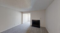 Located in Fort Worth, TX, this single-floor unit offers three bedrooms, one bathroom, a living room, kitchen, hallway, and closet within a compact and efficiently arranged floor plan. The carpeted living room serves as the heart of the home, highlighted by a classic black-tiled fireplace with a white mantel — a standout architectural feature that adds warmth and character. A textured ceiling runs throughout the common areas, contributing to the unit's traditional aesthetic. Natural light filters in through a window visible from the living area, keeping the space feeling open and welcoming. The bedrooms are carpeted and neutral in tone, with the primary bedroom featuring a ceiling fan with light fixture, providing both comfort and functionality. The hallway connects the bedrooms to the kitchen, which is equipped with black appliances and hard-surface flooring, offering a practical contrast to the carpeted rooms. The bathroom includes a full tub-shower combination with white tile surround and clean fixtures. The entry area features hard-surface flooring and recessed lighting, creating a clean transition into the living space. Overall, the unit presents a straightforward, functional layout suitable for comfortable everyday living.