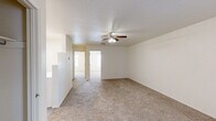 Located at 2135 Payne St in Las Cruces, New Mexico, this single-story home offers three bedrooms and one bathroom within a practical and efficiently organized floor plan. The living area features neutral-toned carpet and a textured ceiling with a ceiling fan, creating a bright and airy atmosphere. The layout flows naturally from the living space into the kitchen and bedroom hallway.

The kitchen is equipped with white cabinetry, a full suite of white appliances including an electric range, dishwasher, and refrigerator, complemented by wood-look vinyl flooring that adds a clean, modern touch. Ample counter space and a double-basin sink complete the functional cooking area.

Each of the three carpeted bedrooms is fitted with a ceiling fan and light fixture. The primary bedroom features mirrored sliding closet doors, adding a sense of depth to the space. The secondary bedrooms receive natural light through blinded windows with views of the surrounding neighborhood greenery.

The bathroom includes a combined shower and bathtub with clean white fixtures, wood-look flooring, and a vanity with cabinet storage beneath. Throughout the home, the light, neutral color palette and consistent finishes create a cohesive and move-in-ready environment suited for comfortable everyday living.
