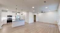Located at 4600 East McKinney Street in Denton, TX, this well-appointed 2-bedroom, 1-bathroom home offers a thoughtfully designed single-floor layout with modern finishes throughout. The open-concept kitchen and living area serves as the heart of the home, featuring light wood-look flooring, recessed lighting, and a ceiling fan. The kitchen is outfitted with crisp white cabinetry, granite countertops, stainless steel appliances including a refrigerator, electric range, microwave, and dishwasher, plus a central island with pendant lighting and an integrated sink — ideal for both cooking and casual dining. The spacious living area benefits from natural light streaming through multiple windows and offers direct access to an outdoor area via a glass door. The generously sized primary bedroom features plush carpeting, a ceiling fan, and bright windows with exterior views. The second bedroom provides a clean, versatile space with wood-look flooring. The full bathroom is finished with white cabinetry, granite countertops, a tub-shower combo, and brushed nickel fixtures. A dedicated closet adds practical storage. Clean white walls and consistent finishes throughout give the home a cohesive, contemporary feel.