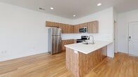 Located in Provo, Utah, this single-floor unit offers a well-designed layout that maximizes every square foot. The open-concept kitchen and living area serves as the heart of the space, featuring light wood-tone cabinetry, a white quartz peninsula with an undermount sink, and a full suite of stainless steel appliances including a refrigerator, electric range, and built-in microwave. A classic white subway tile backsplash adds a clean, modern touch, while recessed lighting illuminates the entire area. Light hardwood-style flooring flows seamlessly throughout, creating a warm and cohesive aesthetic. The living area is bright and open, benefiting from multiple windows dressed with horizontal blinds that invite natural light while maintaining privacy. White walls and a textured ceiling keep the space feeling fresh and airy. The full bathroom continues the consistent design language, featuring warm wood-tone vanity cabinetry, a white countertop, and a tub/shower combination. An in-unit laundry area is also present, adding everyday convenience. Overall, this space delivers a clean, contemporary feel with practical, well-chosen finishes throughout.