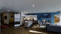 Located at 310 South College Avenue in Fort Collins, Colorado, this modern unit is part of the Uncommon Fort Collins community, designed to offer an elevated living experience. The single-floor layout showcases an open-concept design that seamlessly connects the kitchen and living areas, creating a spacious and inviting atmosphere.

The kitchen is a standout feature, boasting white shaker-style cabinetry with under-cabinet lighting, a sleek white quartz-style countertop, and a central island with bar seating — ideal for casual dining or entertaining. Stainless steel appliances, including a full-sized refrigerator and microwave, provide modern functionality. Dark hardwood-style flooring runs throughout, adding warmth and contrast against the crisp cabinetry.

The living area is anchored by a bold deep-blue accent wall, which adds a striking visual element to the space. A wall-mounted flat-screen TV and thoughtfully placed lighting fixtures enhance the contemporary aesthetic. Recessed lighting throughout keeps the space bright and well-lit, complementing the natural light that filters in.

The overall ambiance is modern, clean, and vibrant — reflecting the Uncommon brand's commitment to stylish, community-focused living in the heart of Fort Collins.