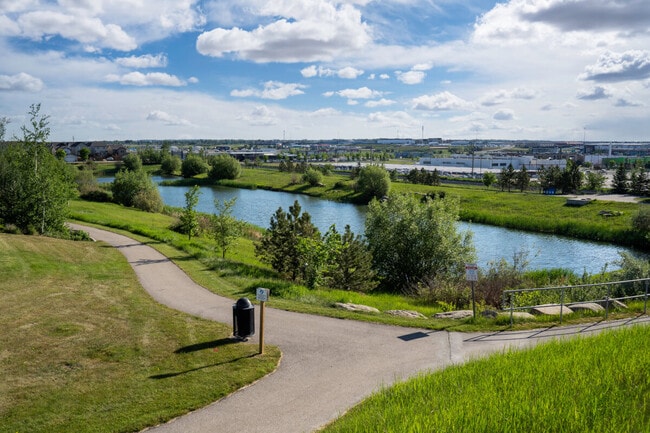 A storm retention pond creates natural habitat in a new urban community with bike paths in Airdrie, Alberta.