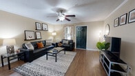 Located at 1000 High Rd in Tallahassee, FL, this single-floor residence offers a thoughtfully designed layout with a comfortable blend of functionality and style. The open living and dining area serves as the heart of the home, finished with warm hardwood-style flooring, crown molding, and a textured ceiling. A ceiling fan anchors the space, while an accent wall adds a bold pop of color. A pass-through window connects the living area to the kitchen, enhancing the open feel. The galley-style kitchen features dark granite-style countertops, white cabinetry, a double sink, and full appliances including a range, refrigerator, and microwave. The bedrooms are carpeted and each includes a ceiling fan and window with natural light. Closet space is provided in the bedrooms, with at least one featuring a mirrored sliding-door closet with built-in shelving. The bathrooms are equipped with shower/tub combos and hardwood-style flooring. A dedicated in-unit laundry area houses a full-size washer and dryer with overhead shelving for storage. Throughout the residence, neutral wall tones and consistent flooring create a cohesive, move-in-ready atmosphere.