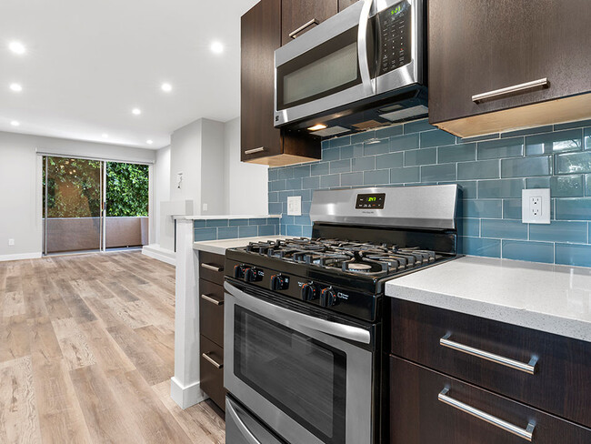 Blue tiled kitchen with stainless steel oven and microwave. - South Hayworth Lofts