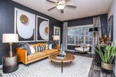 Located at 1570 Sheridan Rd NE in Atlanta's 30324 neighborhood, this single-floor residence showcases a bold, contemporary design with a carefully curated color palette and thoughtful detailing throughout. The open-concept living and dining area serves as the heart of the home, featuring rich hardwood-style flooring, a textured ceiling, and large windows fitted with plantation shutters that invite abundant natural light. The living room is anchored by dramatic dark-painted walls, creating a striking backdrop for the space. A dedicated sitting nook with a wide bay window offers a bright, inviting retreat within the living area. The kitchen is well-appointed with rich dark cabinetry, granite countertops, stainless steel appliances, and a vibrant teal subway tile backsplash that adds a pop of color. The primary bedroom features a bold teal accent wall and plush carpeting, while a second bedroom offers neutral tones and generous natural light through blinded windows. The bathroom includes dark wood cabinetry, granite countertops, and a tub-shower combination. An in-unit laundry area with a full-size washer provides added convenience. Open shelving near the entry adds both style and functionality to the overall layout.