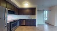 Located on the fifth floor at 1525 SW 11th Ave in Portland's vibrant SW neighborhood, this contemporary unit offers a thoughtfully designed single-floor layout. The kitchen is a standout feature, equipped with dark espresso cabinetry, stainless steel appliances including a GE range, built-in microwave, and dishwasher, complemented by light quartz countertops and a herringbone-pattern tile backsplash. A stylish sliding barn door connects the kitchen to the open living area, which features light wood-tone flooring, bright white walls, and a wall-mounted mini-split HVAC unit for year-round comfort. Large windows flood the living space with natural light and offer views of the surrounding cityscape. The bedroom is similarly bright, benefiting from floor-to-ceiling windows that bring in generous amounts of daylight. The bathroom is cleanly finished with a tub-shower combination, dark vanity cabinetry with a white countertop, and light tile flooring. Throughout the unit, the design maintains a clean, modern aesthetic with consistent use of light flooring and neutral tones, creating a cohesive and functional living environment.