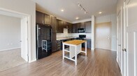 Located at 406 SW 9th St in Des Moines, Iowa, this two-bedroom, two-bathroom unit offers a practical and well-designed layout across a single floor. The kitchen is a standout feature, showcasing rich dark-brown cabinetry with brushed chrome hardware, light countertops, wood-look flooring, and a full suite of black appliances including a range, microwave, and refrigerator. Track lighting and recessed fixtures illuminate the space effectively, and there is ample room for a freestanding island.

Both bedrooms are carpeted and feature neutral wall tones, creating a calm and comfortable atmosphere. Natural light filters in through large windows offering views of the surrounding neighborhood. Each bedroom is paired with a dedicated closet outfitted with wire shelving systems, providing generous and organized storage.

The two bathrooms continue the dark cabinetry theme seen in the kitchen. One bathroom features a vanity with a white countertop, wood-look tile flooring, and a sleek mirror, while the second includes a full bathtub and shower combination. Wood-look flooring extends through the bathrooms and common areas, tying the unit together with a cohesive, modern aesthetic. The overall design is clean, functional, and move-in ready.