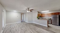 Located at 604 Laurel Lake Ct in Orlando, FL, this single-floor, 3-bedroom, 2-bathroom home offers a well-designed layout with a cohesive, neutral aesthetic throughout. The open-concept living, dining, and kitchen area forms the heart of the home, unified by light-toned wood-look flooring and soft gray walls. A ceiling fan with integrated lighting anchors the living space, which flows seamlessly toward a hallway leading to the bedrooms.

The kitchen is well-appointed with warm honey-toned cabinetry, granite-style countertops, a peninsula breakfast bar, and a full suite of stainless steel appliances including a refrigerator, range, and dishwasher. A dedicated entry door adjacent to the kitchen provides convenient access.

Each of the three bedrooms features the same wood-look flooring, neutral wall tones, and louvered bi-fold closet doors offering ample storage. The primary bedroom includes a ceiling fan and a window that brings in natural light. The secondary bedrooms also feature windows with outdoor views of surrounding greenery.

Both bathrooms are finished with granite-style countertops, warm wood cabinetry, large mirrors, and modern vanity lighting. The home also includes a laundry area, utility room, balcony, and six closets, providing generous storage and functional living space throughout.