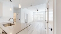 Located at 760 NW Shoal Creek Parkway in Kansas City, MO, this single-floor home offers three bedrooms and three bathrooms within a thoughtfully designed, modern layout. The open-concept living and kitchen area serves as the heart of the home, featuring light hardwood-style flooring, a ceiling fan, and a large window that fills the space with natural light. The kitchen is well-appointed with white shaker-style cabinetry, a subway tile backsplash, stainless steel appliances including a refrigerator with ice maker, electric range, and built-in microwave, along with a spacious island with a taupe countertop and undermount sink with a brushed nickel faucet. Pendant lighting adds a refined touch above the island. The bedrooms are carpeted for comfort, with at least one featuring a ceiling fan, a closet with hanging rod, and a window with blinds. The primary bedroom is generously sized with hardwood-style flooring and convenient access to additional spaces. The bathrooms are finished in a clean, contemporary style with white cabinetry, taupe countertops, black hardware accents, tile flooring, and a subway-tiled tub-shower combination. A light-filled hallway connects the rooms seamlessly, completing this polished and functional home.