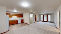 Located on Stoney Creek Drive in Shelby Township, Michigan, this two-story, two-bedroom, two-bathroom home offers a well-organized layout spread across two floors. The main level features an open-concept design where the kitchen, dining room, and living room flow seamlessly together. The kitchen is equipped with warm oak cabinetry, white appliances including a refrigerator and electric range, and a sink with a window, all set on easy-care hard flooring. The living room is carpeted and opens directly to a balcony through a glass door with vertical blinds, allowing natural light to fill the space. Stairs lead to the upper level, which hosts both bedrooms. The generously sized primary bedroom features soft carpet, a large window overlooking lush greenery, and access to multiple closets. The second bedroom is similarly carpeted and naturally lit with outdoor views. Both bathrooms feature oak vanities with light countertops, tile flooring, and tub/shower combinations. A dedicated laundry room with washer/dryer hookups and a utility room with a water heater add everyday convenience. Neutral tones and warm wood trim carry throughout, creating a cohesive and functional living environment.