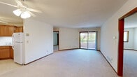 This single-floor, 3-bedroom, 2-bathroom home offers a practical and comfortable layout designed to maximize everyday living. The open living area is bright and inviting, featuring plush wall-to-wall carpeting, neutral-toned walls, and a sliding glass door that opens to a private balcony with outdoor views — allowing natural light to fill the space throughout the day. A ceiling fan adds to the comfort of the area.

The kitchen is well-equipped with warm honey-toned wood cabinetry, a white electric range, black dishwasher, over-the-range microwave, and a double sink. Tile flooring and ample counter space make it both functional and easy to maintain.

The generously sized primary bedroom offers a large walk-in closet outfitted with extensive wire shelving for organized storage. Additional bedrooms are carpeted with natural light from windows, and one conveniently houses a stacked in-unit washer and dryer with sliding wood-panel closet doors providing extra storage.

Both bathrooms are finished with tile flooring and clean, neutral fixtures. The full bathroom features a soaking tub and shower combination, while the second bath includes a vanity with wood cabinetry, a lighted mirror, and a tub-shower unit. Rich wood-toned trim and door accents run throughout, tying the home's interior together cohesively.