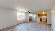 Located at 214 Gilbert in Mesa, Arizona, this single-floor unit offers a practical and well-organized layout designed for comfortable everyday living. The open living area is a standout feature, showcasing light wood-look laminate flooring, a textured ceiling, and a ceiling fan. Two vertical-blind-covered windows and a sliding glass door flood the space with natural light while providing direct access to an outdoor patio area. The adjacent kitchen is efficiently designed in a U-shaped configuration, featuring warm oak cabinetry, light countertops, a stainless steel sink, and a white electric range with overhead ventilation. The consistent wood-look flooring carries through the kitchen seamlessly. A well-lit hallway connects the private areas of the unit, lined with closet storage and wall sconce lighting. The bedrooms are clean and neutrally finished, each with the same wood-look flooring, textured ceilings, and windows that bring in natural light. Two bathrooms serve the unit — one features a shower-tub combo with stainless steel grab bars for added accessibility and a wood-tone vanity, while the second offers a separate soaking tub and a matching vanity with a mirror. The consistent neutral palette and durable flooring throughout give the space a cohesive, move-in-ready appeal.