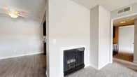 Located at 4390 Casa Grande Circle in Cypress, CA, this 2-bedroom, 1-bathroom single-floor residence offers a well-designed layout with a comfortable, functional flow throughout. The living room is a standout space, featuring vaulted ceilings with exposed white beams, plush carpeting, and a classic fireplace framed in white — creating a warm, inviting focal point. A ceiling fan adds practicality, while a sliding glass door opens to a private balcony, flooding the room with natural light and providing pleasant outdoor views. The kitchen is well-appointed with rich dark wood cabinetry, stone-toned countertops, wood-look flooring, and stainless steel appliances including a refrigerator and dishwasher, alongside a gas range. The primary bedroom is generously sized, featuring soft carpet, a sliding-door closet with built-in rod storage, and direct access to the shared bathroom. The bathroom is clean and functional, offering a full tub-shower combination, wood-look flooring, and a dark wood vanity with a stone-toned countertop. A hallway connects the main living areas, completing this thoughtfully arranged and move-in-ready home in Southern California.