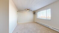 Located at 120 Meyer Rd in Buffalo, NY, this single-floor unit offers four bedrooms, one bathroom, a kitchen, a hallway, and a closet. The layout is straightforward and functional, with neutral-toned walls and wall-to-wall carpeting throughout the bedroom areas, creating a cohesive and understated aesthetic.

The spacious primary bedroom is the largest of the four rooms, featuring a ceiling fan with integrated lighting, a wall-mounted air conditioning unit, a textured ceiling, and a large window fitted with blinds that allows natural light to fill the room. Baseboard heating runs along the exterior wall for year-round comfort. The additional bedrooms are similarly appointed with carpet flooring, baseboard heating, and windows overlooking the surrounding neighborhood, with some rooms including closets with panel-style bifold doors.

The galley-style kitchen is equipped with rich wood cabinetry, granite-style countertops, a tile backsplash, stainless steel range, and a dishwasher, all set over light hardwood-style flooring. The bathroom features tile flooring, a white vanity with a granite countertop, a mirror, and clean, neutral finishes. Throughout the unit, clean white trim, consistent flooring choices, and ample natural light contribute to a bright, practical living environment.