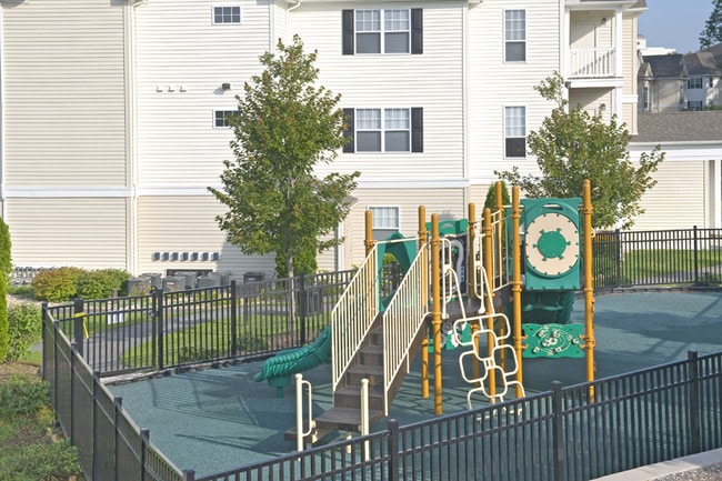 Picnic areas, BBQ grills, an outdoor fireplace, and a children's play area - Highlands at Dearborn Apartments