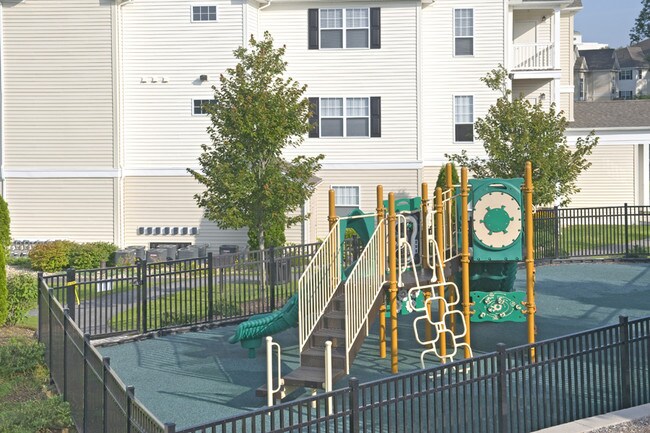 Áreas de pícnic, parrillas para barbacoa, chimenea al aire libre y área de juegos infantiles - Highlands at Dearborn Apartments