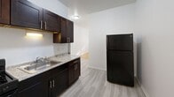 Located on S King Dr in Chicago's South Side, this 2-bedroom, 1-bathroom unit offers a clean, functional layout on a single floor. Throughout the main living areas and bedrooms, warm hardwood floors add character and a timeless aesthetic, complemented by crisp white walls that keep the space feeling bright and open.

The living room provides a welcoming common area with natural light filtering in, flowing conveniently toward the hallway that connects the rest of the unit. Each bedroom features the same rich hardwood flooring, white walls, and windows with natural views of surrounding greenery. Cast-iron radiators in the bedrooms are a classic Chicago architectural detail, providing efficient radiant heat. The primary bedroom offers a comfortable footprint with closet access, while the second bedroom is equally well-appointed.

The kitchen is fitted with dark espresso cabinetry, granite-look countertops, a gas range, stainless steel sink, and a full-size refrigerator, all set on light wood-look flooring. A window above the door brings in additional natural light. The bathroom features a tub/shower combo with warm beige tile surround, a white vanity with mirror, and light-toned flooring. Three closets throughout the unit provide ample storage for a space of this size.