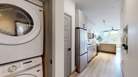 Located in Denver's Capitol Hill neighborhood, this thoughtfully designed one-bedroom, one-bathroom residence offers a modern open-concept layout with clean lines and contemporary finishes throughout. Light-toned hardwood-style flooring flows seamlessly from the living area through the kitchen, creating a cohesive and welcoming atmosphere.

The living room is a bright, airy retreat anchored by floor-to-ceiling windows that invite abundant natural light and offer views of the surrounding neighborhood. A ceiling fan adds comfort, while track lighting in the adjoining areas provides versatile illumination.

The kitchen is efficiently laid out with tall white cabinetry, stainless steel appliances including a full-size refrigerator, and a breakfast bar with seating — ideal for casual dining or entertaining. Tucked conveniently nearby is an in-unit stacked washer and dryer, adding practical day-to-day convenience.

The generously sized bedroom features a ceiling fan, soft neutral walls, and direct access to a dedicated closet with built-in shelving and hanging rods, providing ample storage. The bathroom is finished with crisp white subway tile surround and a soaking tub equipped with matte black fixtures, offering a spa-like aesthetic. This residence combines functional design with modern style in one of Denver's most vibrant urban neighborhoods.