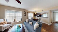 Located at 3453 Timber Run Dr in Valrico, Florida, this single-story home offers a thoughtfully designed layout with warm, neutral tones and consistent finishes throughout. The open-concept living and dining area is bright and welcoming, with multiple windows dressed in horizontal blinds that allow generous natural light to fill the space. Rich hardwood-style flooring runs through the main living areas, complemented by ceiling fans that add both function and style.

The kitchen is well-equipped, featuring rich cherry-toned cabinetry, granite countertops, a tile backsplash, a double-basin sink, and black appliances. A breakfast bar seamlessly connects the kitchen to the dining and living spaces, creating an ideal flow for everyday living and entertaining.

The bedrooms offer comfortable retreats, with plush carpeting, large windows with sheer curtains, and ceiling fans. The primary bedroom stands out with vaulted ceilings, adding a sense of spaciousness and architectural interest. The bathrooms are finished with granite-topped vanities, rich wood cabinetry, hardwood-style flooring, and shower-tub combinations. A sitting area off the main living space provides an additional relaxed gathering spot. Overall, the home presents a cohesive, comfortable aesthetic with quality finishes throughout.