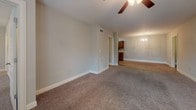Located at 3085 Commonwealth Dr in Spring Hill, Tennessee, this single-story home offers a well-designed layout with a mix of hardwood-style and carpeted flooring throughout. The galley-style kitchen is a functional highlight, featuring rich dark wood cabinetry, granite countertops, a tile backsplash, and black appliances including a range and refrigerator. The kitchen connects seamlessly to the dining area, which is accented by an elegant chandelier and warm hardwood-style flooring.

The living room is generously sized with neutral carpet, a ceiling fan, and an open sightline into the dining and kitchen areas. Multiple bedrooms feature plush carpet, ceiling fans with lighting, and windows with blinds that allow for natural light and privacy. The primary suite includes a well-appointed bathroom with hardwood-style flooring, a soaking tub, a separate shower, a granite-topped vanity with dark wood cabinetry, and access to a walk-in closet with built-in shelving. A secondary bathroom mirrors the same quality finishes, with a granite vanity, wood cabinetry, and a tub-shower combination. Neutral gray wall tones and clean white trim carry throughout, giving the home a cohesive and move-in-ready feel.
