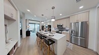 This well-designed 630-square-foot, one-bedroom, one-bathroom apartment offers a thoughtful single-floor layout that maximizes every square foot. Light wood flooring flows consistently throughout, creating a cohesive and airy aesthetic across all rooms.

The open-concept living room connects directly to a private balcony via floor-to-ceiling sliding glass doors, filling the space with natural light and outdoor views. The kitchen is a standout feature, equipped with light wood cabinetry extending to the ceiling, a gray tile backsplash, stainless steel appliances including a French door refrigerator and over-the-range microwave, and a white quartz waterfall island with bar seating and an undermount sink — ideal for both cooking and casual dining.

The 140-square-foot primary bedroom features a tray ceiling, ceiling fan, and a large window with outdoor views. The bathroom offers a glass-enclosed walk-in shower, white quartz vanity, gray cabinetry, and large-format tile flooring. It connects directly to a dedicated walk-in closet outfitted with adjustable shelving, hanging rods, and ample storage. A hallway completes the layout, providing smooth circulation throughout the unit.