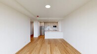 Located at 2140 North Lincoln Park West in Chicago's coveted Lincoln Park neighborhood, this thoughtfully designed 2-bedroom, 1-bathroom apartment offers a clean, modern aesthetic throughout. Light-toned hardwood floors flow seamlessly across the entire unit, creating a bright and cohesive feel.

The open-concept living and kitchen area serves as the heart of the home. The kitchen is well-appointed with shaker-style cabinetry in a warm off-white finish, black hardware accents, white quartz countertops, a subway tile backsplash, and a full suite of stainless steel appliances including a refrigerator, dishwasher, oven range, and built-in microwave. A peninsula provides additional counter space and separation from the living area.

A bright hallway connects the living space to the two bedrooms and bathroom. The primary bedroom is generously sized and features a large window with scenic views of the surrounding greenery. The second bedroom is well-proportioned and versatile. Both rooms are bathed in natural light.

The bathroom is a standout feature, showcasing a walk-in glass shower with white tile surround, black fixtures, and a striking geometric hexagonal tile floor that adds visual character. The unit is completed by a clean, white hallway with built-in storage.