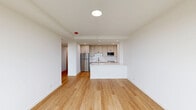 Located at 2140 North Lincoln Park West in Chicago's coveted Lincoln Park neighborhood, this thoughtfully designed 2-bedroom, 1-bathroom apartment offers a clean, modern aesthetic throughout. Light-toned hardwood floors flow seamlessly across the entire unit, creating a bright and cohesive feel.

The open-concept living and kitchen area serves as the heart of the home. The kitchen is well-appointed with shaker-style cabinetry in a warm off-white finish, black hardware accents, white quartz countertops, a subway tile backsplash, and a full suite of stainless steel appliances including a refrigerator, dishwasher, oven range, and built-in microwave. A peninsula provides additional counter space and separation from the living area.

A bright hallway connects the living space to the two bedrooms and bathroom. The primary bedroom is generously sized and features a large window with scenic views of the surrounding greenery. The second bedroom is well-proportioned and versatile. Both rooms are bathed in natural light.

The bathroom is a standout feature, showcasing a walk-in glass shower with white tile surround, black fixtures, and a striking geometric hexagonal tile floor that adds visual character. The unit is completed by a clean, white hallway with built-in storage.