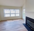 This 1350 square foot home in Stamford, CT offers a blend of space and functionality across two floors. The ground floor spans 900 square feet, while the upper level provides an additional 460 square feet of living space. The property boasts four bedrooms, including a generous 200 square foot primary bedroom, offering ample space for rest and relaxation.

The home's single bathroom features modern fixtures, a vanity with storage, and a combination tub/shower, adorned with decorative tiling. The kitchen is equipped with white cabinetry, granite countertops, and full-sized appliances, including a gas range and refrigerator. A combined kitchen and living area creates an open, sociable atmosphere.

A standout feature is the living room's vaulted ceiling, which adds volume and light to the space. The room is further enhanced by a sleek, modern fireplace, perfect for cozy evenings. Flooring varies throughout, with hardwood in main living areas and plush carpeting in bedrooms.

The property includes an in-unit laundry room with a top-loading washer, adding convenience to daily life. Large windows and sliding glass doors in some rooms provide natural light and potential outdoor access. The neutral color palette throughout allows for easy personalization, making this house a blank canvas for its occupants to create their ideal home.