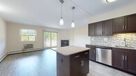 Located at 340 Media Station Rd in Media, PA, this one-bedroom, one-bathroom residence offers a well-designed single-floor layout with a thoughtful mix of modern updates and comfortable living spaces. The open-concept kitchen is a standout feature, showcasing dark espresso cabinetry, a mosaic tile backsplash, granite countertops, stainless steel appliances including a dishwasher and refrigerator, and a central island with pendant lighting overhead — ideal for both cooking and casual dining. The kitchen flows seamlessly into the living room, which features light hardwood-style flooring, a classic fireplace, and sliding glass doors that open onto a private balcony. The balcony offers serene, lush wooded views, bringing an abundance of natural light and greenery into the space. The generously sized bedroom is carpeted for comfort, includes a dedicated closet, and receives natural light through its windows. The full bathroom is finished with large-format tile surrounding the tub and shower, a granite-topped vanity, and coordinating tile flooring. Additional features include a hallway, a closet for storage, and baseboard heating throughout. This residence combines modern finishes with a tranquil natural setting.