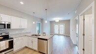 Located at 8601 Old Highway 60 in Sellersburg, Indiana, this two-story home offers a thoughtfully designed layout spread across two floors. The main level welcomes you through a dedicated entrance that opens to a bright living room with wood-look flooring and clean neutral tones. The kitchen is a standout feature, showcasing white shaker cabinetry, granite countertops, stainless steel appliances including a refrigerator, range, microwave, and dishwasher, and a peninsula with pendant lighting — all flowing seamlessly into the living area. A versatile den with French doors offers views of the outdoors and additional flexible living space. A full bathroom with a walk-in shower, granite vanity, and wood-look flooring, along with a dedicated laundry room with side-by-side washer and dryer, round out the main level. Upstairs, three bedrooms feature plush carpet, ceiling fans, and generous natural light from large windows. The bedrooms are well-served by ample closet space, including walk-in closets with wire shelving systems. Two additional bathrooms continue the granite vanity finishes seen throughout. With seven total closets and consistent modern finishes across both floors, this home balances practical functionality with comfortable, contemporary style.